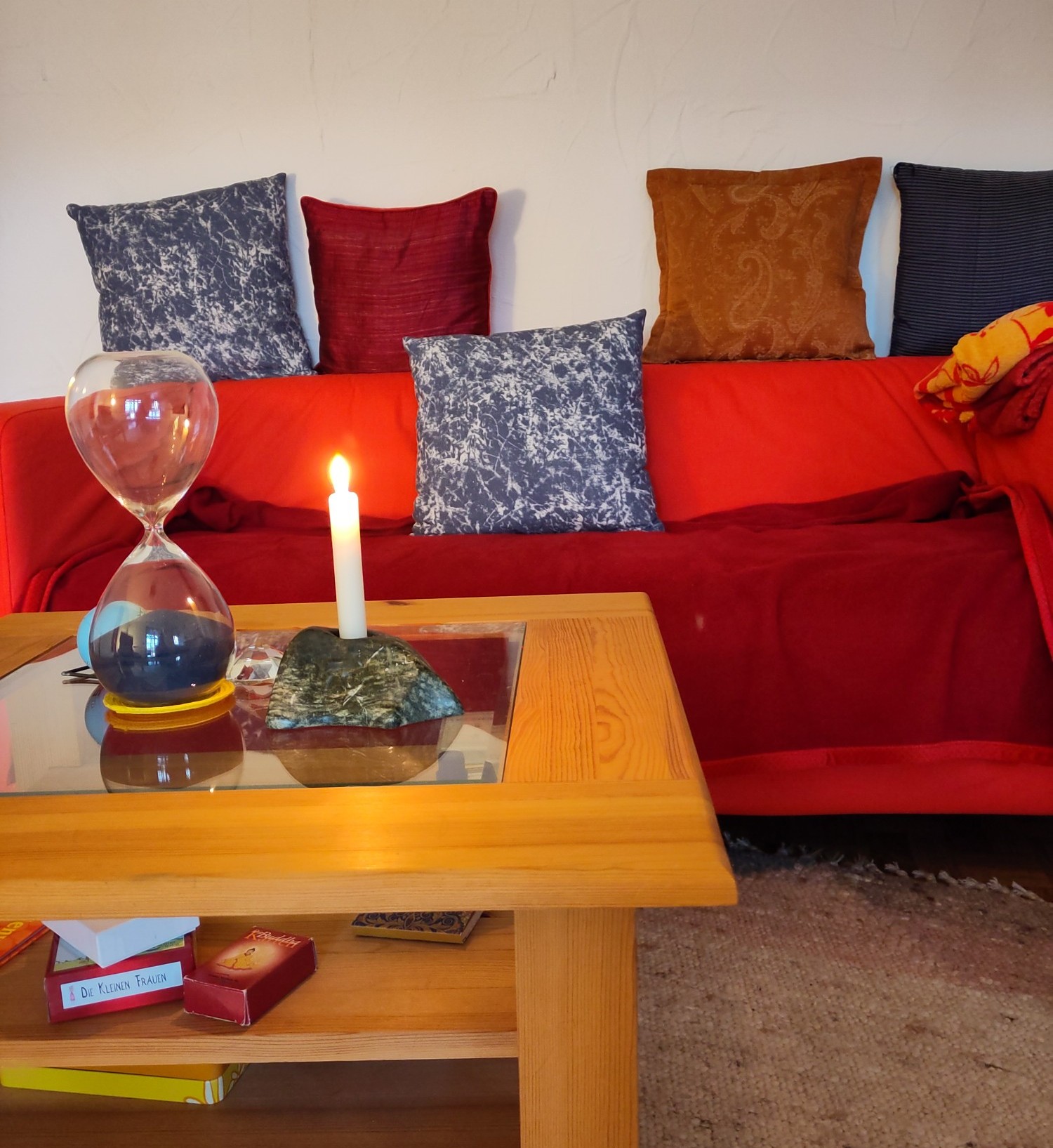 ein rotes Sofa hinter Tisch mit Kerze